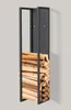 A tall, narrow black metal firewood rack filled with stacked logs, standing against a light gray wall. Podgląd zdjęcia produktu