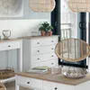 A bright and airy room with a chest of drawers, a coffee table, and a rattan chair. Anteprima dell’immagine prodotto