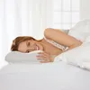 A woman is lying on a bed with a pillow. Produktbild-Vorschau