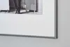 A close-up view of a framed black and white photograph, showing the bottom part of a person's legs and feet, with the frame and matting prominently displayed. Anteprima dell’immagine prodotto