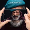 A close-up shot of an elderly man's face, with a smartphone held in front of it, displaying the man's face on the screen. The image is framed by hands holding the phone. Produktbild-Vorschau