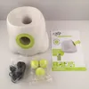 A dog ball launcher and its accessories are laid out on a white surface. Voir les images du produit