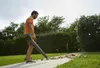 A man is using a leaf blower in a garden on a sunny day. Produktbild-Vorschau