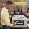 A man is using a Brother MFC-J6940DW A3 Tinten-Multi printer in an office setting. Another person is visible in the background. Voir les images du produit