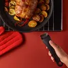A hand is holding a detachable pan handle near a roasting pan filled with a roast and vegetables. Produktbild-Vorschau