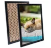 Two black picture frames are shown, one in front of the other. The front frame displays a picture of a sleeping French bulldog on a cushion. The back frame shows a patterned backing. Produktbild-Vorschau