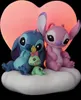 Stitch and Angel figures sitting on a cloud with a heart-shaped light in the background. Anteprima dell’immagine prodotto