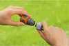 Two hands connecting two parts of a garden hose connector. Náhled obrázku produktu