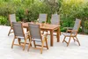 A wooden garden table and six chairs are set up on a patio, surrounded by greenery. Náhled obrázku produktu