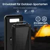 A power bank with a solar panel is shown in front of a blurred tent at night. Produktbild-Vorschau