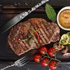 A beautifully presented steak dinner with cutlery and vegetables on a wooden board. Produktbild-Vorschau