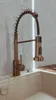 A close-up shot of a modern kitchen faucet with a pull-down sprayer, set against a textured wall with vertical lighting. Anteprima dell’immagine prodotto