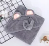 A gray hooded towel shaped like an elephant, folded on a white and black grid background. Produktbild-Vorschau