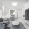 A modern, minimalist living room with a sofa, coffee table, and a view of a dining area and stairs. Náhled obrázku produktu