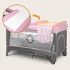 A baby travel cot with a changing table attachment and storage pockets. An inset shows a close-up of the changing mat. Anteprima dell’immagine prodotto