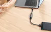 A person's hands are shown using a laptop connected to an external hard drive via an adapter. Náhľad obrázku produktu