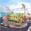 A model of a green tram on a track with cherry blossoms and a blue sky. Produktbild-Vorschau