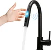 A hand is shown activating a motion-sensor kitchen faucet, which is dispensing water.