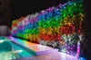 A hedge decorated with rainbow-colored LED lights next to a swimming pool at night. Produktbild-Vorschau