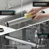A split image showing a stainless steel rolling pin being washed by hand in a sink and then placed in a dishwasher with other kitchen utensils. Produktbild-Vorschau