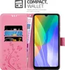 A pink wallet-style phone case with a phone inserted and cards and money in the wallet slots. Náhled obrázku produktu