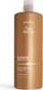 A tall, golden bottle of Wella Professionals Ultimate Smooth Shampoo is shown against a white background. Produktbild-Vorschau