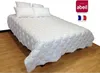 A white quilted bedspread with pillows on a bed, set against a wooden floor and a white background. Produktbild-Vorschau