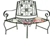 A green metal garden bench with decorative scrollwork and floral motifs. A straw hat and a scarf are placed on the seat. Anteprima dell’immagine prodotto