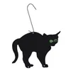 A black cat silhouette ornament with green eyes, hanging from a hook. Voir les images du produit