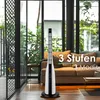 A tower fan is placed in a modern living room with a sofa in the background. Voir les images du produit