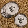 A stack of plates and one plate on the side, all with a bull's head design, are arranged on a bed of straw. Voir les images du produit
