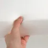 A hand is pressing into a white foam material. Produktbild-Vorschau