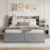 A bedroom scene featuring a gray bed with a headboard bookshelf and a nightstand. Produktbild-Vorschau