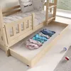 A wooden bunk bed with a pull-out drawer containing folded clothes. Pillows with cute designs are on the top bunk. Produktbild-Vorschau