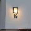 A wall-mounted outdoor light fixture with the number 19 below it. Podgląd zdjęcia produktu