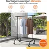 A clothes rack with three t-shirts on display, set against a blurry outdoor background with trees, plants, and an umbrella. Promotional text is overlaid at the top and bottom of the image. Produktbild-Vorschau