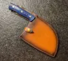 A knife with a blue handle and a brown leather sheath rests on a dark gray textured surface. Anteprima dell’immagine prodotto