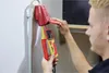 A person is using a voltage tester on an electrical outlet. Náhľad obrázku produktu