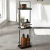 A black metal bathroom shelf unit with various toiletries and bath products on it, placed on a tiled floor next to a bathtub. Podgląd zdjęcia produktu