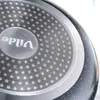 Close-up view of the bottom of a frying pan, showing the textured surface and branding. Náhľad obrázku produktu