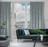 A living room with a sofa and curtains in front of a window overlooking a city. Produktbild-Vorschau