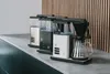 Three coffee makers lined up on a countertop. Produktbild-Vorschau