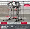 A black and red Smith machine is shown in a gym-like setting with a concrete wall and large windows in the background. Dimensions are indicated with red overlays. Produktbild-Vorschau