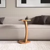 A wooden side table with a cup and a small plant on it, placed next to a sofa. Náhled obrázku produktu