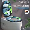 A toilet seat with a decorative design of stones and leaves is shown on a toilet in a bathroom setting. Anteprima dell’immagine prodotto