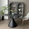 A modern dining room with a round black table, a gray arched bookshelf, and a white chair. Produktbild-Vorschau