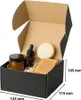 A black cardboard box with its flaps open, containing various cosmetic products and filler material. Dimensions are indicated on the side. Podgląd zdjęcia produktu