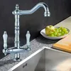 A kitchen faucet with a sink and fruit in the background. Náhled obrázku produktu