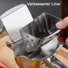 A close-up shot of a stainless steel manual juicer, with a hand holding a part of the juicer. Produktbild-Vorschau