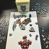 A wooden owl puzzle is being assembled on a white surface, with the box and scattered puzzle pieces visible. Náhled obrázku produktu
